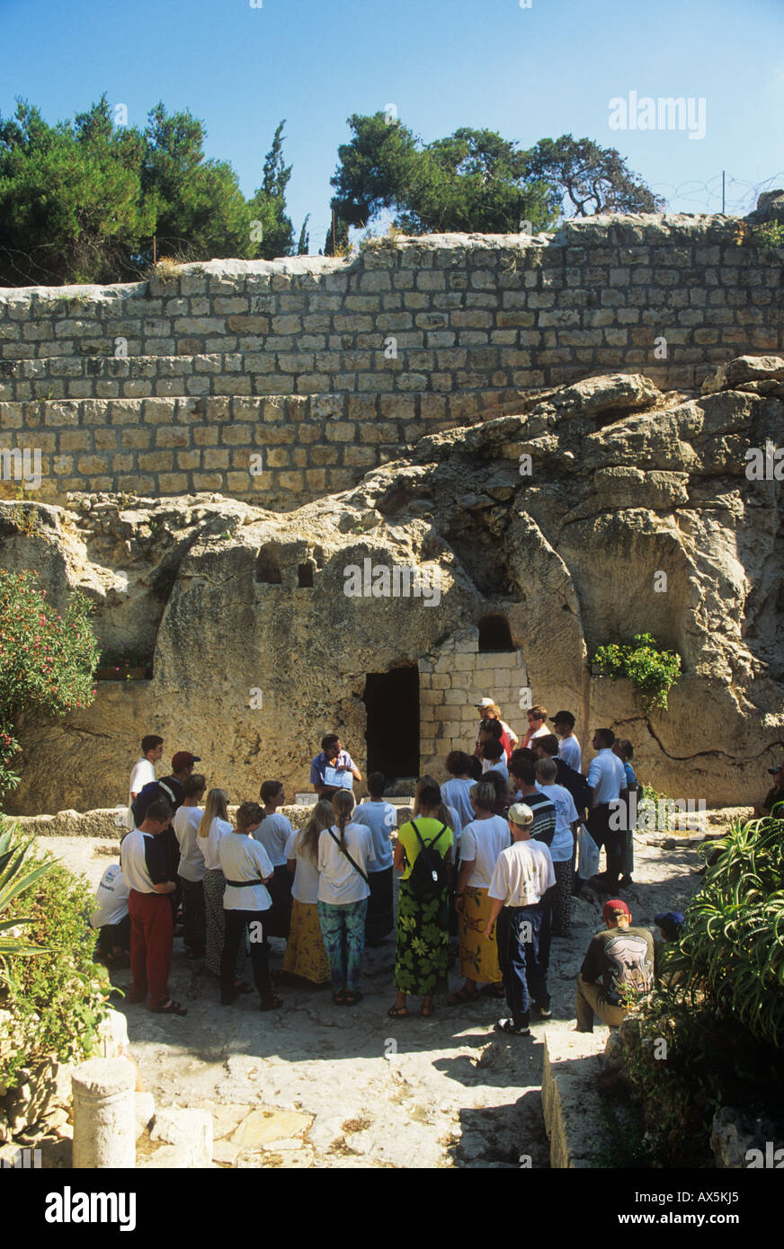 A Christian religious tour group visiting the `Garden Tomb` in Jerusalem believed to be the site of the burial and resurrection of Jesus. Stock Photo